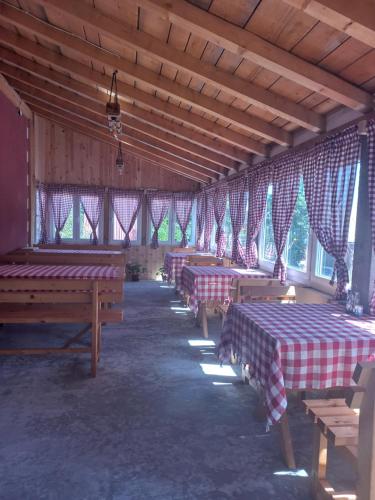 扎布利亚克Apartmani Sobe Sljivancanin的一间设有窗户的谷仓里设有几排桌子的房间