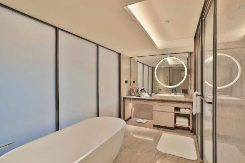 杭州浙江世贸君澜大饭店的带浴缸、水槽和镜子的浴室