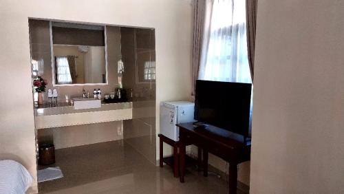 罗威那Grand Melka Hotel的一间带水槽、书桌和镜子的浴室