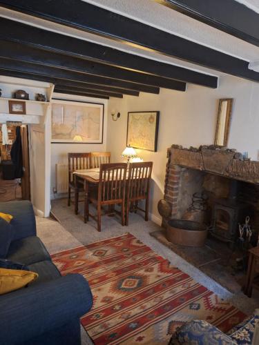 斯泰兹The Cottage, High Street Staithes的客厅配有桌子和壁炉