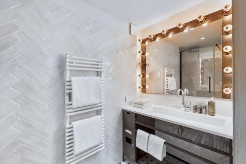 圣但尼H4 Hotel Wyndham Paris Pleyel Resort的一间带水槽和镜子的浴室
