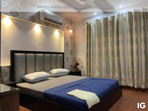 拉合尔3 Bedroom Furnished Holiday Home Near Valencia Town, Lake City & Ring Road的一间卧室配有一张带蓝色床单和白色枕头的床。