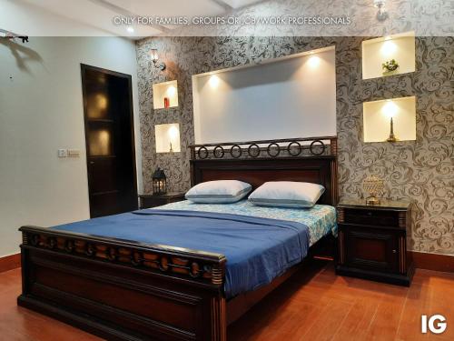 拉合尔3 Bedroom Furnished Holiday Home Near Valencia Town, Lake City & Ring Road的一间卧室配有一张带蓝色棉被的大床