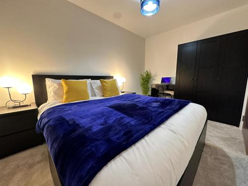 曼彻斯特1 Bed Apartment near Old Trafford with free car park的一间卧室配有一张带蓝色毯子的大床