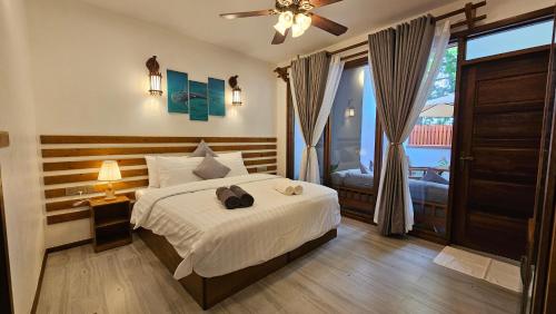 迪古拉Dhonfalhu Dhigurah的一间卧室配有一张床和吊扇