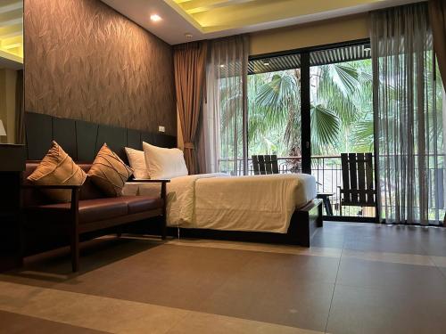 奥南海滩Aonang Hill Krabi-SHA Extra Plus的一间卧室配有一张床、一张沙发和窗户。