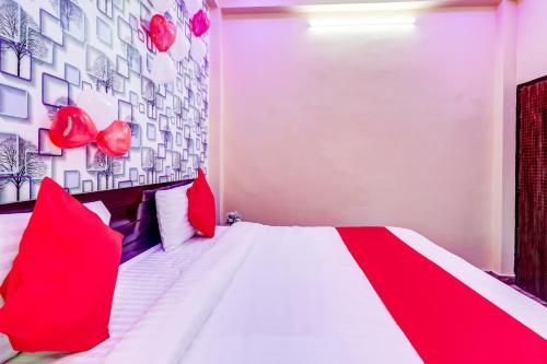 BijnaurOYO Flagship Radhey Krishna Bhawan的卧室配有红色和白色的床和红色枕头