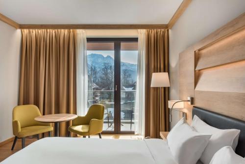 扎科帕内Radisson Blu Hotel & Residences的酒店客房带一张床、一张桌子和椅子