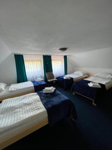 Telnice7Rooms的酒店客房,配有三张带蓝色床单的床