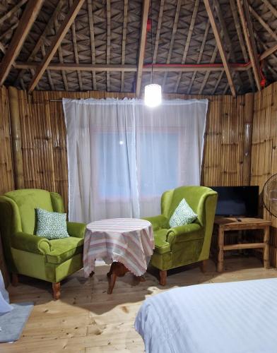 BulusanBirbeck Lodge的一间设有两把椅子、一张桌子和一张床的房间