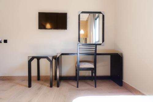 卡萨布兰卡Ennesma Hotel的一张桌子、椅子和墙上的镜子