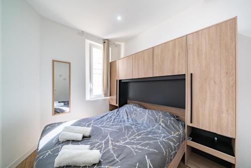 昂蒂布Joli 2 pièces au coeur du Centre-Ville - AW的一间卧室配有一张带大型木制床头板的床