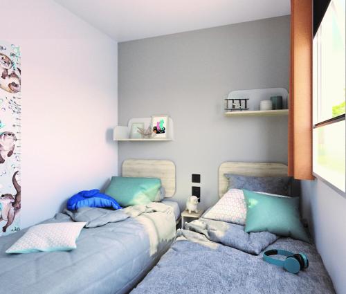 卡斯泰莱托索普拉蒂奇诺丽都韦尔巴诺库斯露营地的配有两张床铺的蓝色和绿色枕头