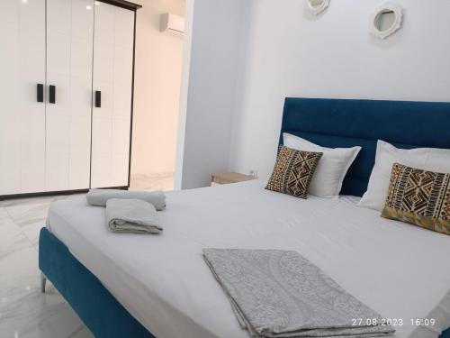 莫纳斯提尔LEO Haute standing appartment S1 center Monastir的一张大床,在房间内有一个蓝色床头板
