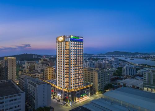 汕头汕头澄海智选假日酒店的一座高大的建筑,城市里灯火通明