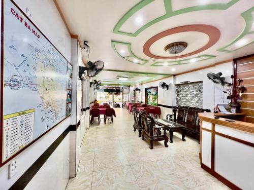 吉婆岛Manh Vuong Hotel的一间设有桌椅的餐厅,墙上有地图