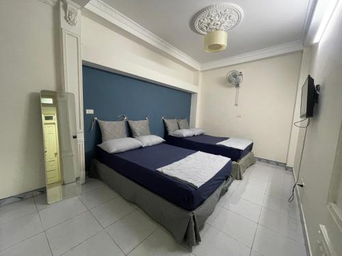 河内Sword lake hostel的一间卧室设有两张床和蓝色床头板