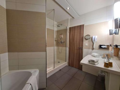 利布尔讷利布尔讷圣艾米隆美居酒店的带浴缸、淋浴和盥洗盆的浴室