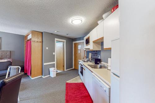 大白山Whitefoot Lodge 342/344的厨房配有白色橱柜和红色地毯