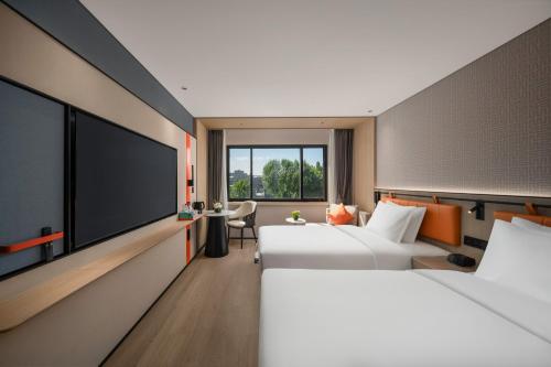 北京北京礼士智选假日酒店的酒店客房设有两张床和一台平面电视。