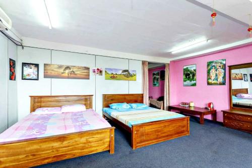 科伦坡Beehive Colombo的一间卧室设有两张床,墙壁粉红色