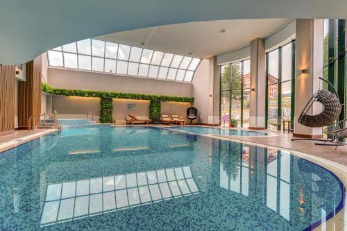 潘波洛沃Grand Hotel Murgavets的一座大型游泳池,位于一座带大窗户的建筑内