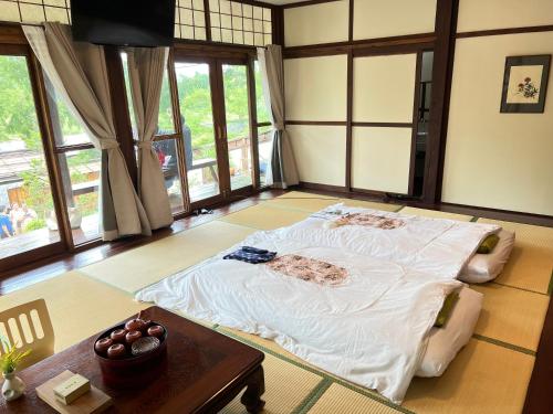 清道เรียวกัง ยามะโฮชิ Ryokan Yamahoshi เชียงใหม่的一张大床,位于带桌子的房间