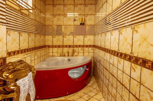 胡志明市KEN 2 HOTEL的一间铺有瓷砖的客房内的红色浴缸的浴室