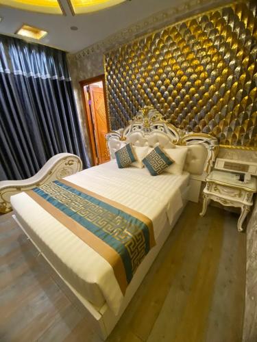胡志明市KEN 2 HOTEL的一间卧室配有白色的床,拥有蓝色和金色的墙壁
