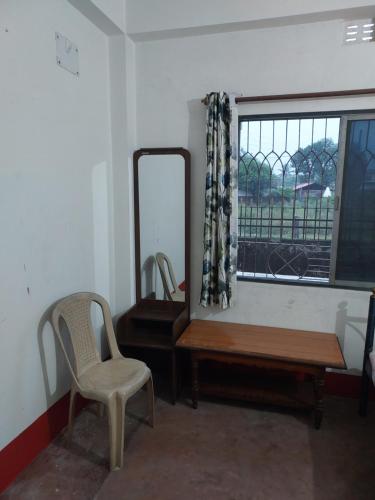 西里古里Lama Residence的一间设有镜子、椅子和桌子的房间