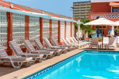 达喀尔拉马德拉戈 - 冲浪海滩碧海酒店的连排躺椅和一个游泳池