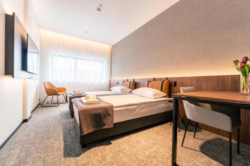 维尔纽斯潘塔德乌什酒店的配有一张床和一张书桌的酒店客房