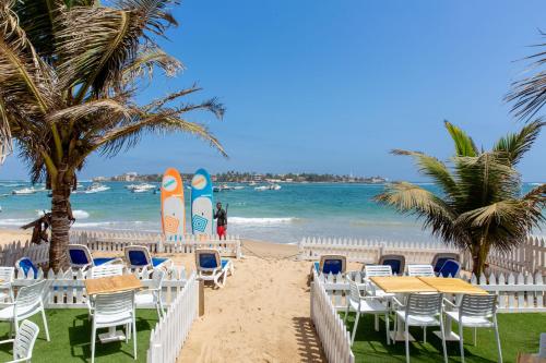 达喀尔拉马德拉戈 - 冲浪海滩碧海酒店的海滩上设有桌椅和冲浪板