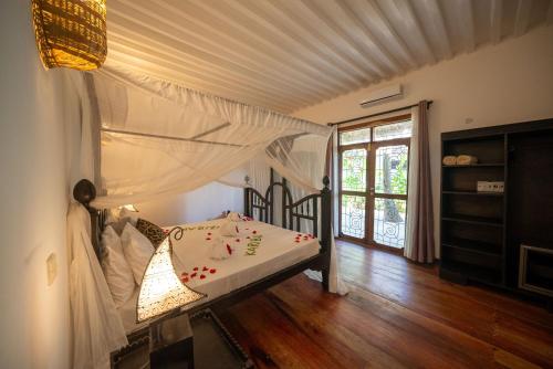 吉汶瓦Beachfront Turtle House ZanzibarHouses的一间卧室配有一张带天蓬的床