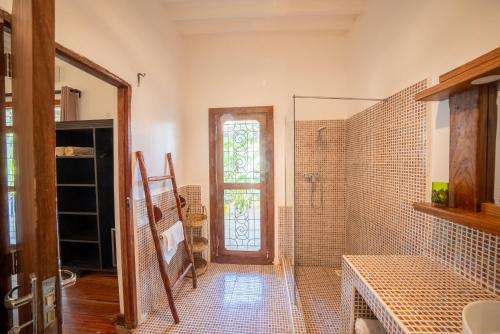 吉汶瓦Beachfront Turtle House ZanzibarHouses的带淋浴的浴室和玻璃门