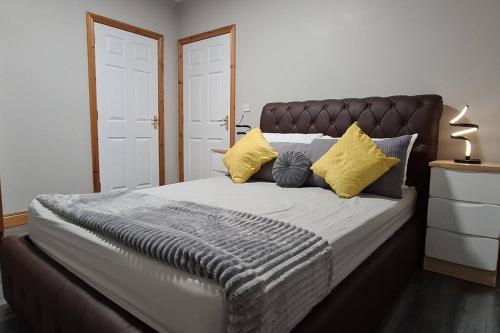 安特里姆Millhouse Cottage A Luxury 3 bed Bungalow的一间卧室配有一张带黄色枕头的大床