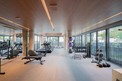 阿雷格里港Condomínio GO24的健身房设有跑步机、有氧器材和窗户