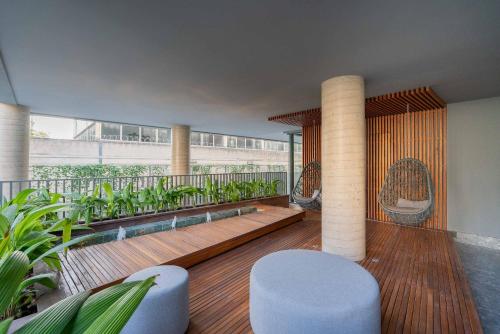 阿雷格里港Condomínio GO24的大楼内的阳台配有椅子和植物
