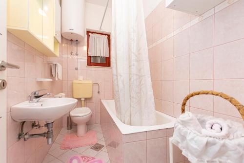 杜埃Apartments Tonci的浴室配有盥洗盆、卫生间和浴缸。