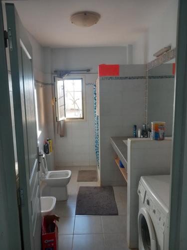 NdéyaneCasa Kassi的浴室配有卫生间水槽和洗衣机。