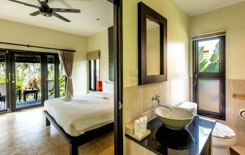 蔻立Phukhaolak Resort的一间卧室配有一张床,浴室设有水槽