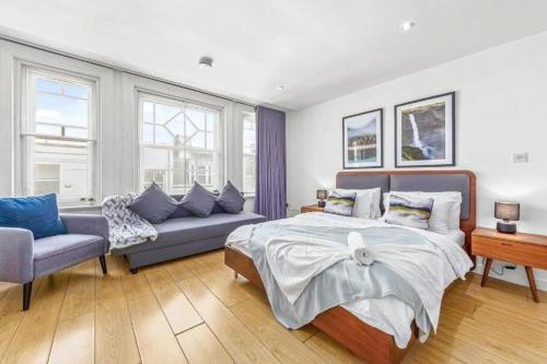 伦敦1 BR Flat Piccadilly Sleep 7 in London VR10的一间卧室配有一张床和一张沙发