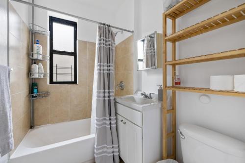 纽约Live Upper Manhattan on a Budget的带浴缸、盥洗盆和卫生间的浴室