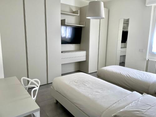 佩罗Domus Pyrus Apartments的白色的客房配有两张床和电视。