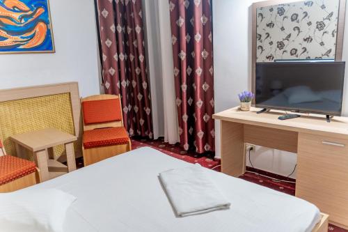 特尔戈维什泰登博维察酒店的配有电视、书桌和椅子的客房