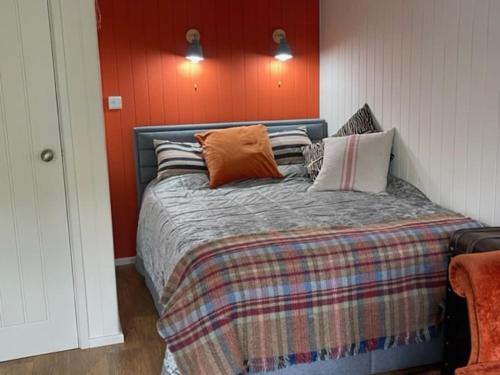 奈顿The Garden Room的一间卧室配有一张橙色墙壁的床