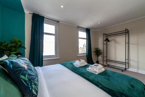 伦敦Stunning 5BR house wgarden & terrace, SE London的一间卧室配有一张大床和毛巾