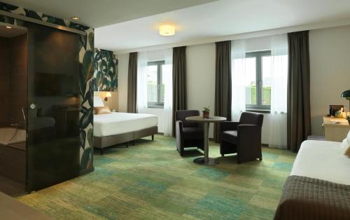 滑铁卢勒克特维赫特酒店的酒店客房带一张床、一张桌子和椅子