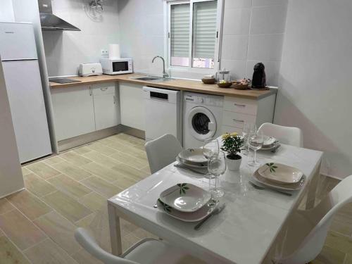 塔拉桑纳阿拉贡Acogedor Apartamento Casco Histórico de Tarazona的厨房配有白色的桌椅和洗衣机。