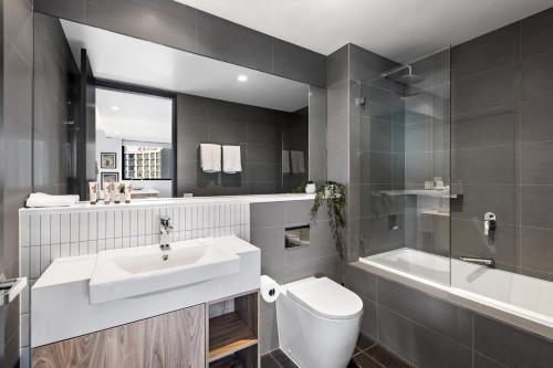 吉朗Quest Geelong Central的浴室配有盥洗盆、卫生间和浴缸。